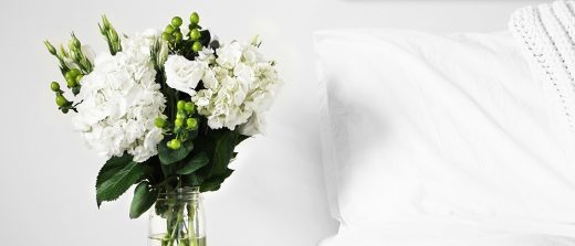 A high-contrast flower bouquet with a comfy Tempur bed beside it.